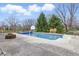 Private outdoor swimming pool with surrounding patio, basketball hoop, and mature trees at 8414 Anchorage Ct, Indianapolis, IN 46236