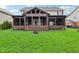 View of the backyard showing off the covered patio area with a fire pit and green lawn at 8650 N Springview Dr, McCordsville, IN 46055