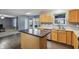 Open-concept kitchen with wood cabinets, an island, and a view of the living room at 8650 N Springview Dr, McCordsville, IN 46055