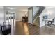 Open-concept living room with hardwood floors, a staircase, and a glimpse of the dining area and kitchen at 8650 N Springview Dr, McCordsville, IN 46055