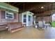 Comfortable covered patio with swing, ceiling fan, and outdoor seating, great for relaxing and entertaining at 8650 N Springview Dr, McCordsville, IN 46055