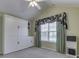 Cozy bedroom featuring a Murphy bed with built-in cabinetry and bright window at 871 Gazebo Way, Greenwood, IN 46142