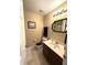Bathroom featuring a toilet, vanity, and decorative mirror and lighting at 9454 Tanhurst Dr, Indianapolis, IN 46250