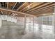 Unfinished basement featuring exposed beams, concrete floor, and access to an outdoor space at 11172 Cliffside Dr, Fortville, IN 46040