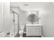 Modern bathroom featuring a shower with glass doors, a round mirror, and updated vanity at 11172 Cliffside Dr, Fortville, IN 46040