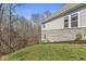 Side exterior showing the stone foundation, siding, lawn, and treeline at 11172 Cliffside Dr, Fortville, IN 46040