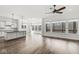 Open-concept living space with hardwood floors, large windows, and a modern ceiling fan at 11172 Cliffside Dr, Fortville, IN 46040
