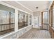 Covered porch with wood floors, stone accents, and open view of nature at 11172 Cliffside Dr, Fortville, IN 46040