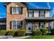 Close up of a two-story brick home with vinyl siding, manicured bushes, and a charming covered front entry at 1228 Knapps Ct, Greenwood, IN 46142