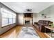 Cozy living room features a brick fireplace, plush brown couch, and a decorative area rug on hardwood floors at 1228 Knapps Ct, Greenwood, IN 46142