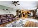 Open-concept living room flows into a kitchen with wooden cabinets and stainless steel appliances; brown leather sofa on the left at 1228 Knapps Ct, Greenwood, IN 46142