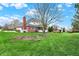 Spacious backyard with manicured lawn, mature trees and garden beds at 13225 Snow Owl Dr, Carmel, IN 46033