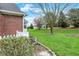 Green backyard with manicured lawn, garden, and mature trees near the house at 13225 Snow Owl Dr, Carmel, IN 46033
