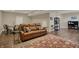 Finished basement with brown leather sofa, hardwood floors and an area rug at 13225 Snow Owl Dr, Carmel, IN 46033