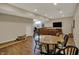 Finished basement with brown leather sofa, TV, hardwood floors, and table at 13225 Snow Owl Dr, Carmel, IN 46033