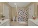 Bright bathroom featuring tile flooring, double vanity, and shower/bath combo with a decorative curtain at 13225 Snow Owl Dr, Carmel, IN 46033