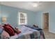 Bedroom with blue walls featuring carpet, ceiling fan, and a window for natural light at 13225 Snow Owl Dr, Carmel, IN 46033