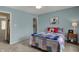 Bedroom with blue walls featuring carpet, ceiling fan, and a door to the walk-in closet at 13225 Snow Owl Dr, Carmel, IN 46033