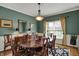 Bright dining room features a chandelier, large table, and a floral rug at 13225 Snow Owl Dr, Carmel, IN 46033