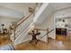 Open foyer featuring hardwood floors, staircase with white railings, and views into adjacent living spaces at 13225 Snow Owl Dr, Carmel, IN 46033
