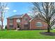 Beautiful brick two-story home with a well-manicured lawn, blossoming trees, and a welcoming entrance at 13225 Snow Owl Dr, Carmel, IN 46033