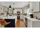 Well-lit kitchen showcases white cabinets, marble countertops, stainless appliances, and a center island at 13225 Snow Owl Dr, Carmel, IN 46033