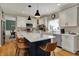 Bright kitchen with white cabinets, marble countertops, stainless appliances, and stylish island with seating at 13225 Snow Owl Dr, Carmel, IN 46033