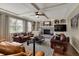 Inviting living room with a brick fireplace, built-in shelves, hardwood floors, and comfortable seating arrangements at 13225 Snow Owl Dr, Carmel, IN 46033