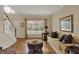 Comfortable living room offers hardwood floors, staircase, and a large window at 13225 Snow Owl Dr, Carmel, IN 46033