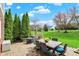 Paver patio with dining set, grill and lush greenery, perfect for outdoor entertaining at 13225 Snow Owl Dr, Carmel, IN 46033
