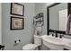 Charming powder room features elegant fixtures, framed artwork, and pedestal sink at 13225 Snow Owl Dr, Carmel, IN 46033