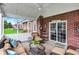 Well-lit screened porch with comfortable seating, brick accents, and access to the backyard for relaxation and entertainment at 13225 Snow Owl Dr, Carmel, IN 46033