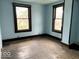 Empty bedroom with blue walls, hardwood floors, and natural light from two windows at 1325 S Hackley St, Muncie, IN 47302