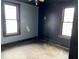 Bedroom featuring hardwood floors, two windows, and dark walls, ready for a fresh renovation at 1325 S Hackley St, Muncie, IN 47302