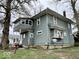 Two-story home featuring an enclosed sunroom, multiple windows, and satellite dishes at 1325 S Hackley St, Muncie, IN 47302
