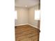 Bright bedroom featuring wood-look flooring, neutral walls, and natural light from the windows at 150 E Troy Ave, Indianapolis, IN 46225