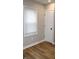 Bright bedroom featuring hardwood floors and a large window with blinds at 150 E Troy Ave, Indianapolis, IN 46225