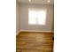 Bright bedroom with wood-look flooring, neutral walls, and a window with horizontal blinds at 150 E Troy Ave, Indianapolis, IN 46225