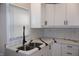 Modern kitchen featuring white cabinets, subway tile backsplash, and stainless sink at 150 E Troy Ave, Indianapolis, IN 46225