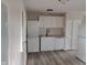 Efficient kitchenette featuring white appliances, stackable washer/dryer, and light wood floors at 1502 Saint John S Ct, Beech Grove, IN 46107
