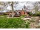 Spacious backyard featuring a brick home, outdoor seating, deck, and green lawn at 1550 Renee Dr, Plainfield, IN 46168