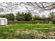Backyard featuring a storage shed, wood fence, mature trees, and a swing set at 1550 Renee Dr, Plainfield, IN 46168