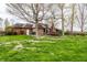 Brick home backyard view showing a deck, patio, and lush lawn perfect for relaxation at 1550 Renee Dr, Plainfield, IN 46168