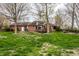 Backyard view showcasing a brick home with a deck, outdoor seating area, and green space at 1550 Renee Dr, Plainfield, IN 46168