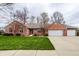 Charming brick home featuring an attached garage and a beautifully manicured lawn at 1550 Renee Dr, Plainfield, IN 46168