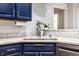 Close up view of a kitchen sink with blue cabinets and stainless steel appliances at 1550 Renee Dr, Plainfield, IN 46168
