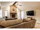 Spacious living room with a cozy brick fireplace, ceiling fan, and comfortable seating at 1550 Renee Dr, Plainfield, IN 46168