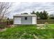 Storage shed with roll-up door in the backyard, surrounded by a well-maintained lawn and wooden fence at 1550 Renee Dr, Plainfield, IN 46168