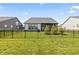 Back exterior view with a screened in porch, an iron fence, and young evergreen trees in the manicured backyard at 15755 Scher Dr, Westfield, IN 46074