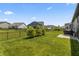 Expansive backyard features lush green grass, ornamental trees, and a sleek black fence for privacy and curb appeal at 15755 Scher Dr, Westfield, IN 46074